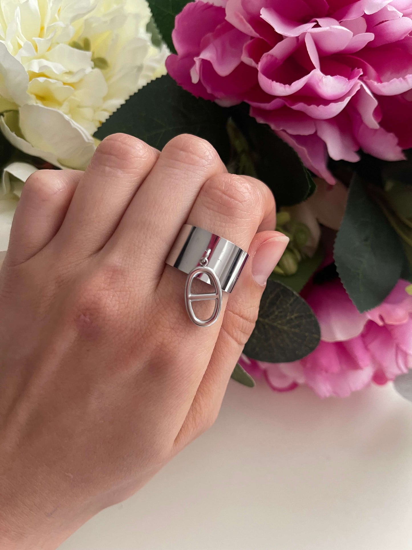 Découvrez notre élégante bague Céline, disponible en deux magnifiques couleurs : doré et argenté.  Fabriquée en acier inoxydable de haute qualité, elle est non seulement résistante à l'eau, mais aussi réglable pour un ajustement parfait.  Sa pampille sophistiquée rappelle l'univers des grandes marques de luxe, ajoutant une touche d'élégance à votre tenue.  Offrez-vous ce bijou raffiné et intemporel qui sublimera chaque instant de votre journée !