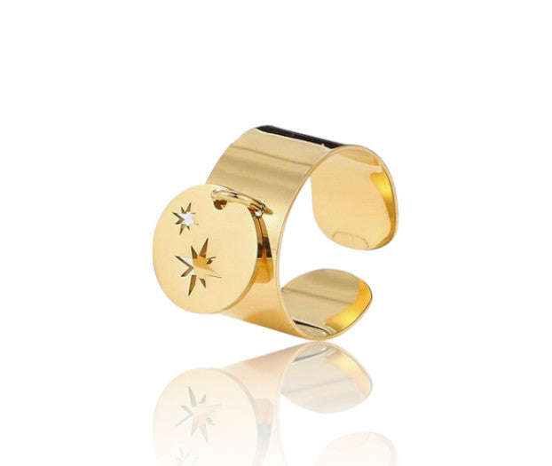 Bague Cora en acier inoxydable, disponible en argent 925 ou doré à l’or fin 18 carats. Réglable, ornée d’un médaillon étoilé. Résistante à l’eau.