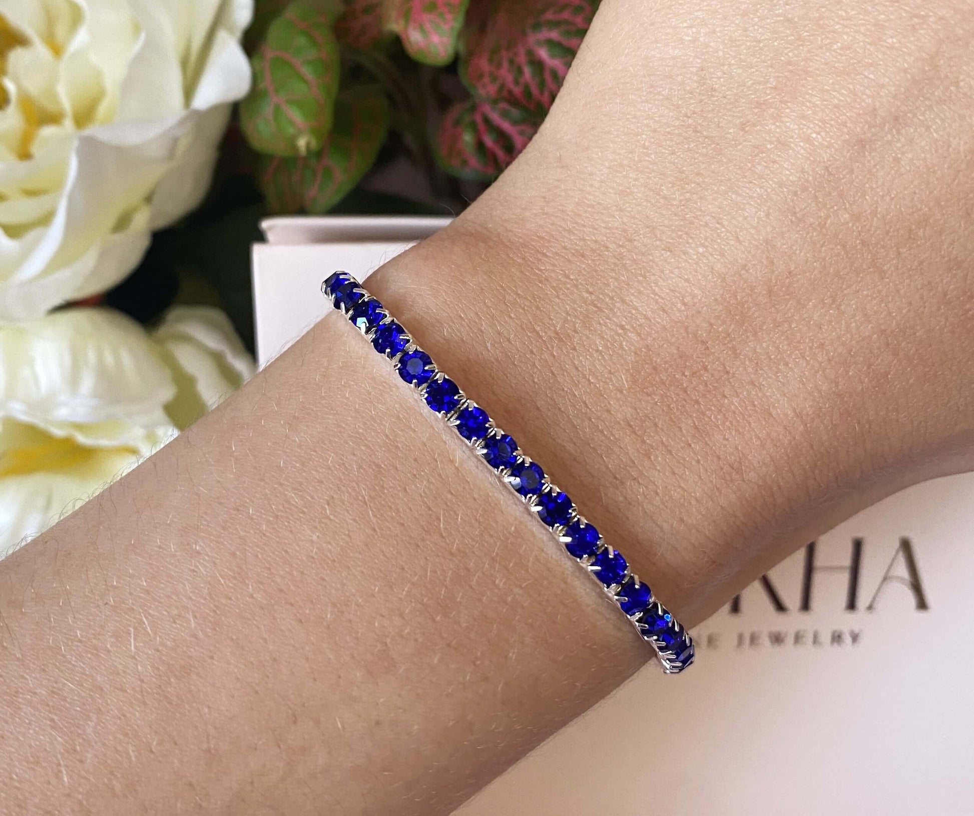 L'aura sophistiquée de ces bijoux sont captivantes.  Le bracelet Hailey ajustable est orné de zircons scintillants avec une belle couleur bleu saphir.