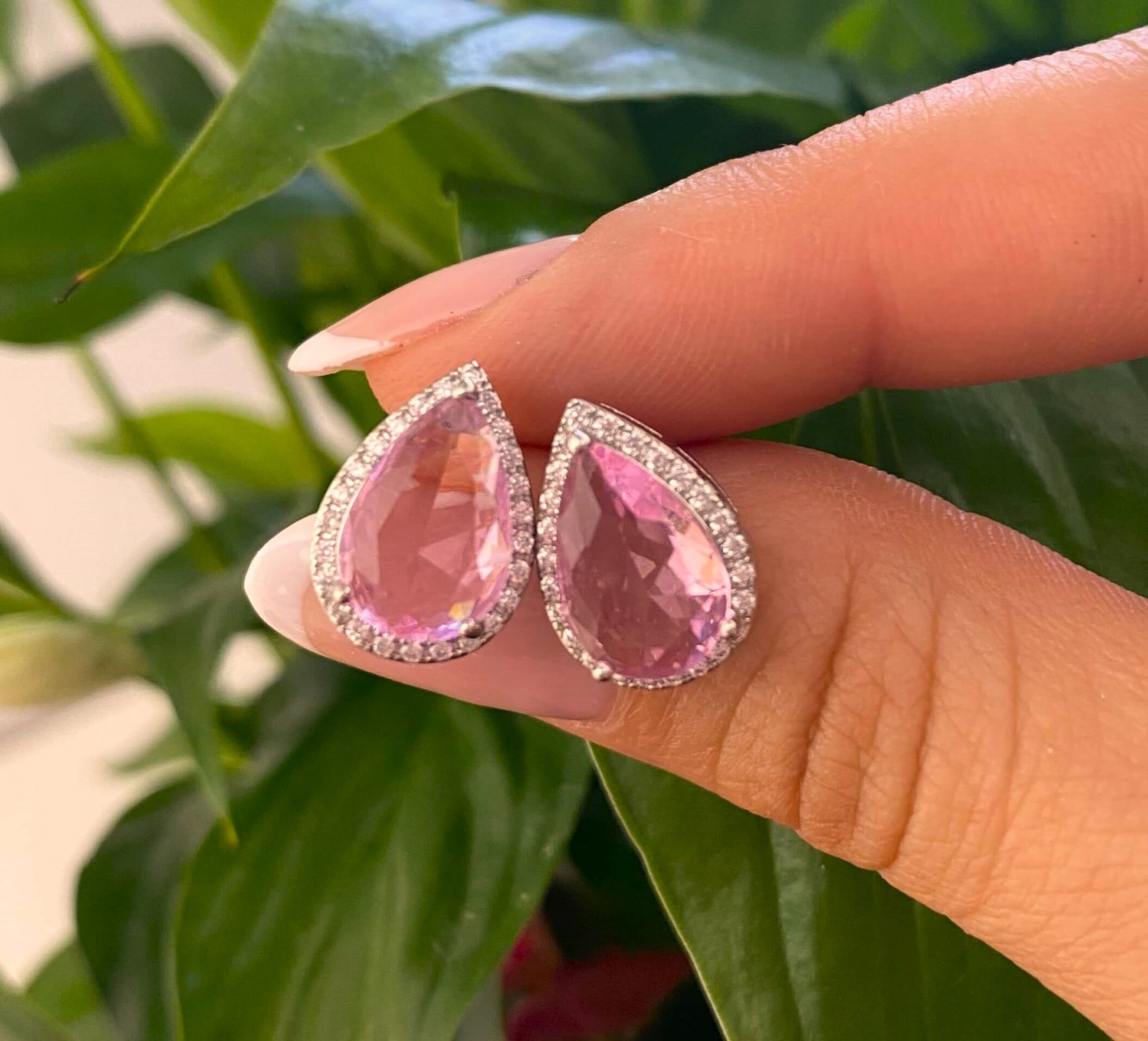 Puces d'oreilles en forme de goutte. Leur cristal rose est entouré de zircons sertit sur un bijoux en acier inoxydable.  Résiste à l'eau.  Vendues par paires.  Convient aux personnes allergiques.