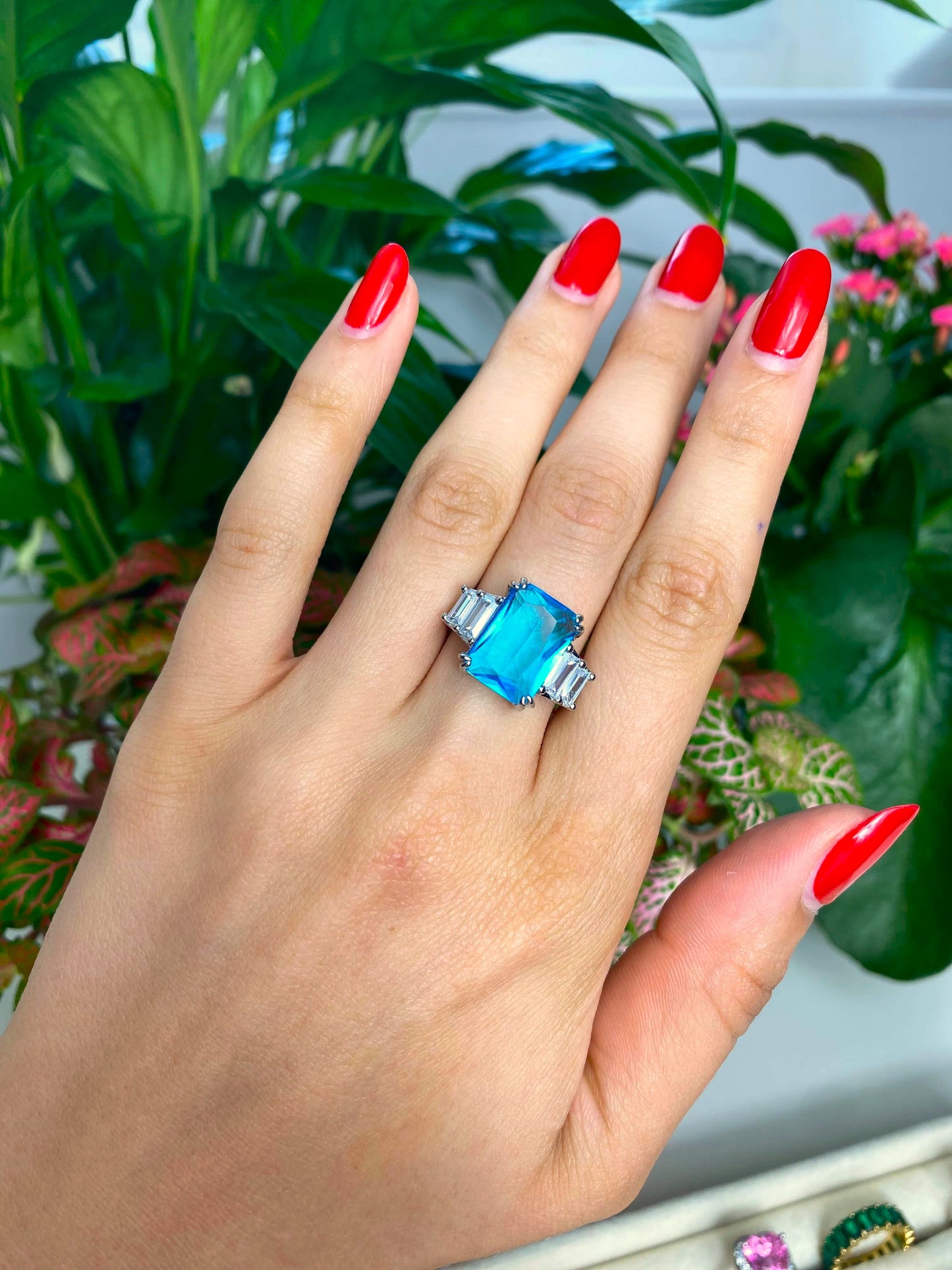 Bague en acier inoxydable sertie d'un magnifique cristal teinté de bleu coupe radiant. Ainsi que de plusieurs cristaux blancs du plus bel effet.  Bague réglable.  Résiste à l'eau.