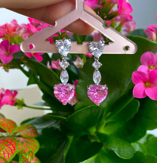 Boucles d'oreilles pendante en acier inoxydable incrusté de zircons blancs, qui sublime un magnifique cristal teinté de rose.  Ces boucles d'oreilles font parties de la parure Enchanted comprenant un collier, un bracelet et une paire de boucles d'oreilles.  Résiste à l'eau.  Vendues par paires.  Convient aux personnes allergiques.