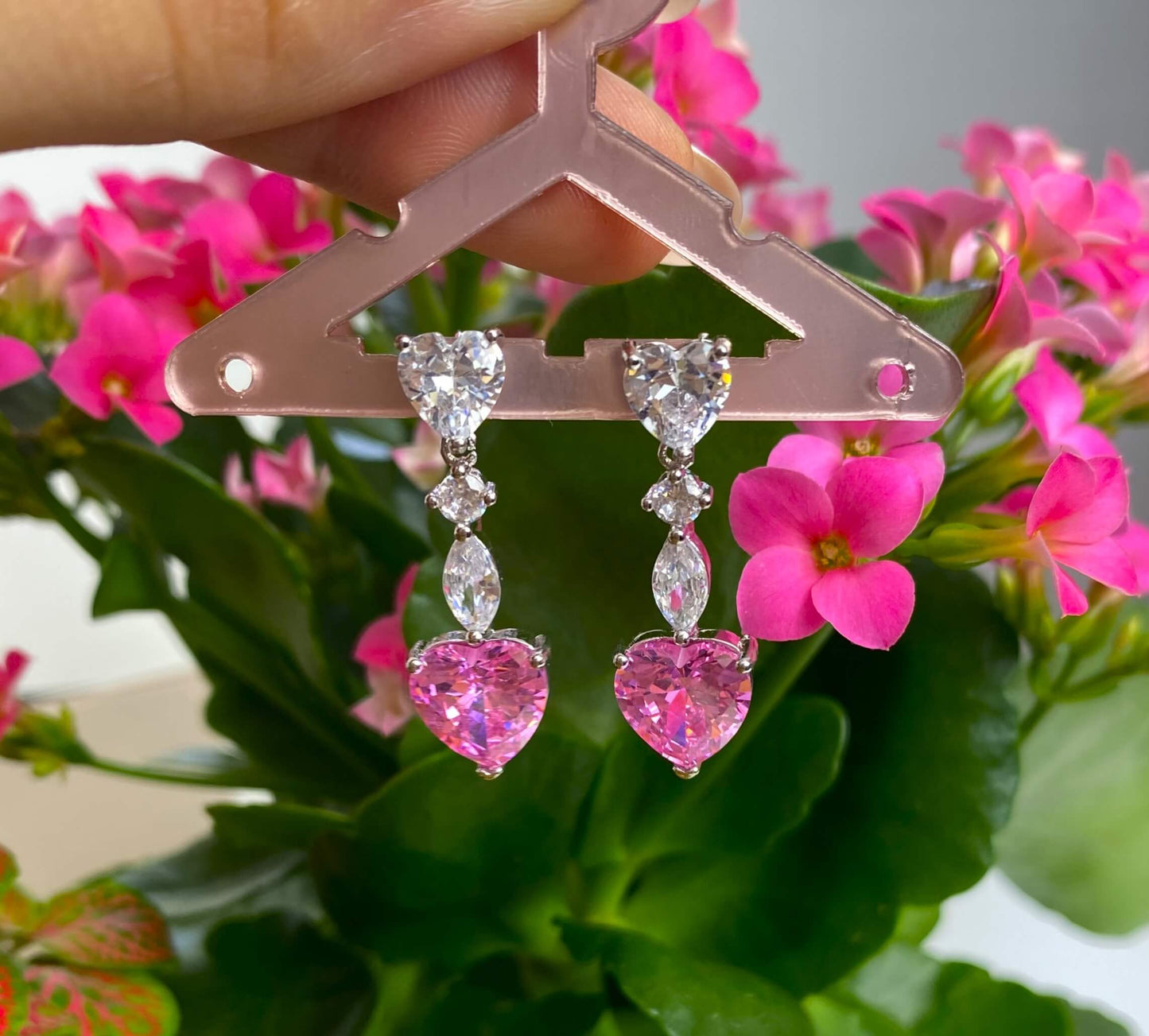 Boucles d'oreilles pendante en acier inoxydable incrusté de zircons blancs, qui sublime un magnifique cristal teinté de rose.  Ces boucles d'oreilles font parties de la parure Enchanted comprenant un collier, un bracelet et une paire de boucles d'oreilles.  Résiste à l'eau.  Vendues par paires.  Convient aux personnes allergiques.