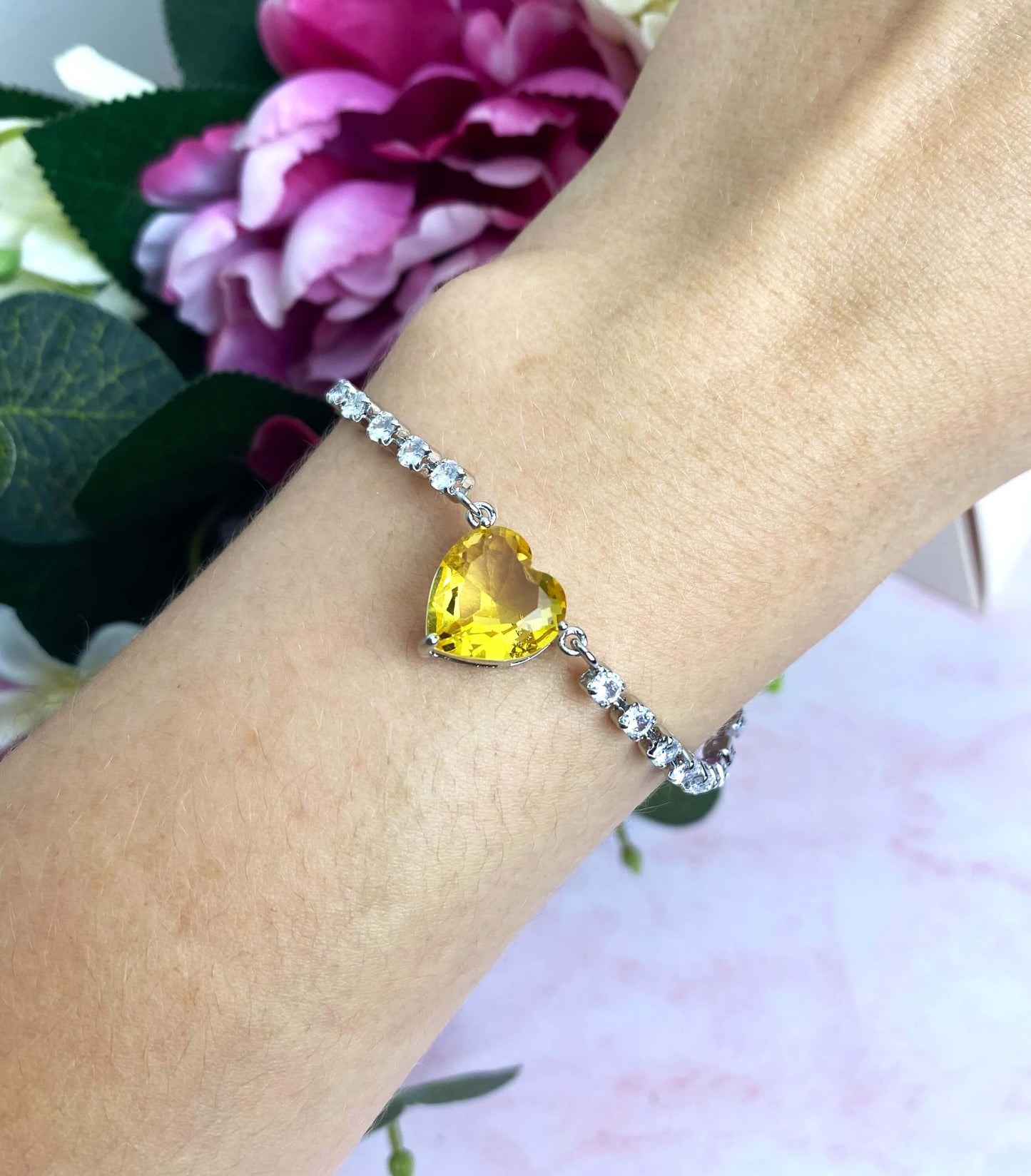 Paré de strass et d'un somptueux cœur jaune en cristal, le bracelet Enchanted vous transporte avec sa chaîne réglable et ses incroyables zircons brillants. Choisissez parmi les couleurs rose, bleu ou jaune.  Fabriqué en acier inoxydable, ce splendide bracelet est résistant à l'eau. 