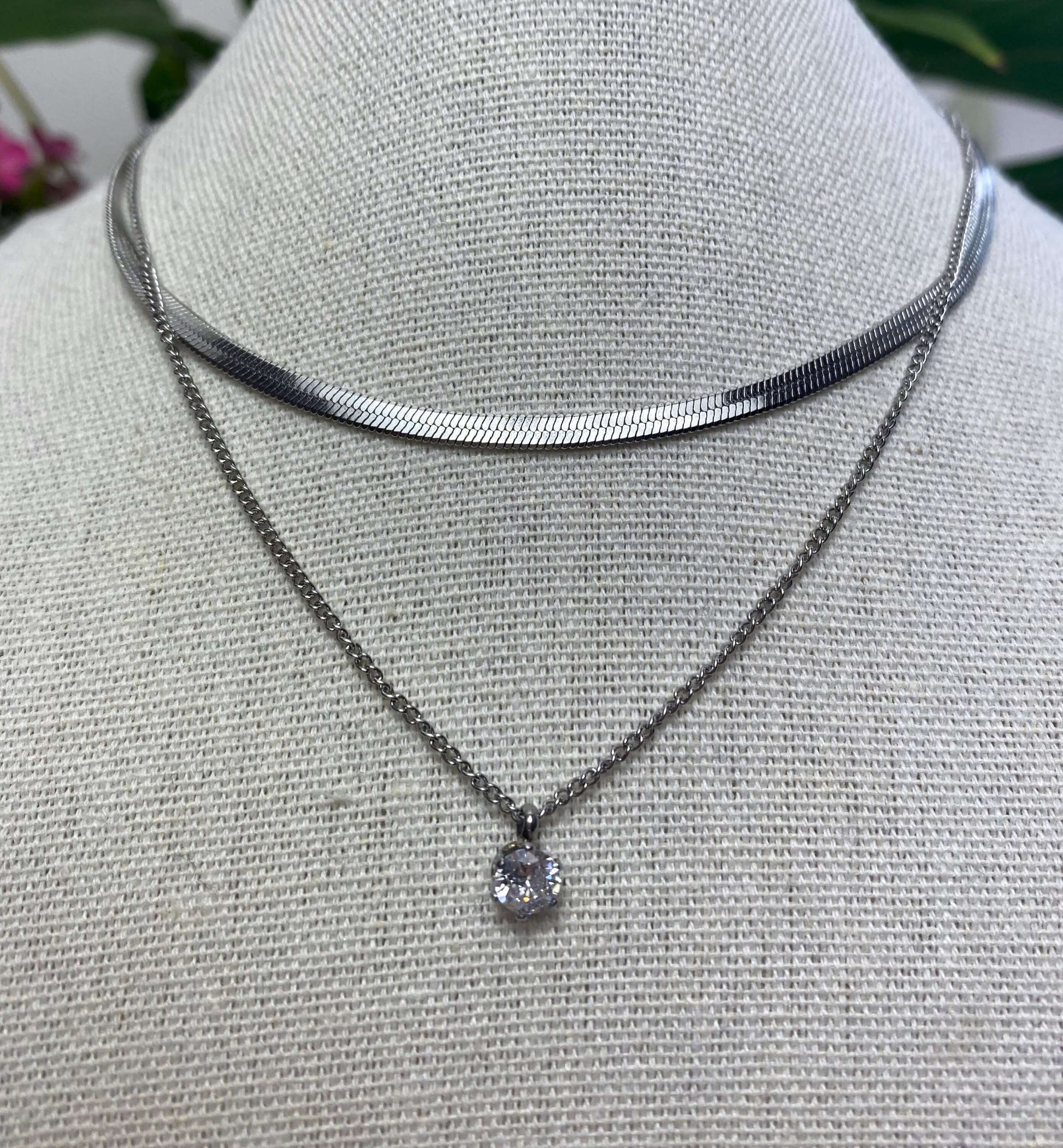 L'éclatant et délicat.  Collier comportant deux chaînes réglable embellit d'un pendentif en zircon.  Résiste à l'eau.  Disponible en acier inoxydable et plaqué or 18k ou en argent 925.  Chaine réglable de 46 à 60cm.