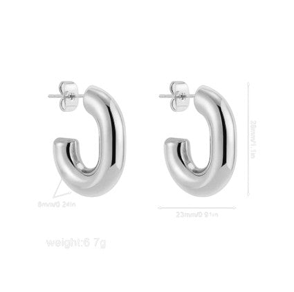 Boucles Lyra en acier inoxydable or ou argent. Minimalistes, brillantes et résistantes à l’eau. L'élégance pure au quotidien.