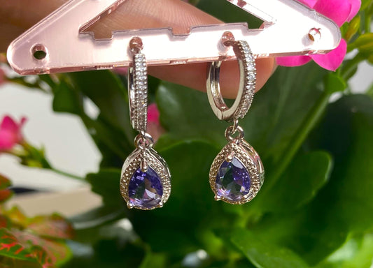 Boucles d'oreilles pendantes mise en valeur par un remarquable zircon taille Princesse de 7mm.  Résiste à l'eau.  En acier inoxydable.  Vendues par paires.  Convient aux personnes allergiques.