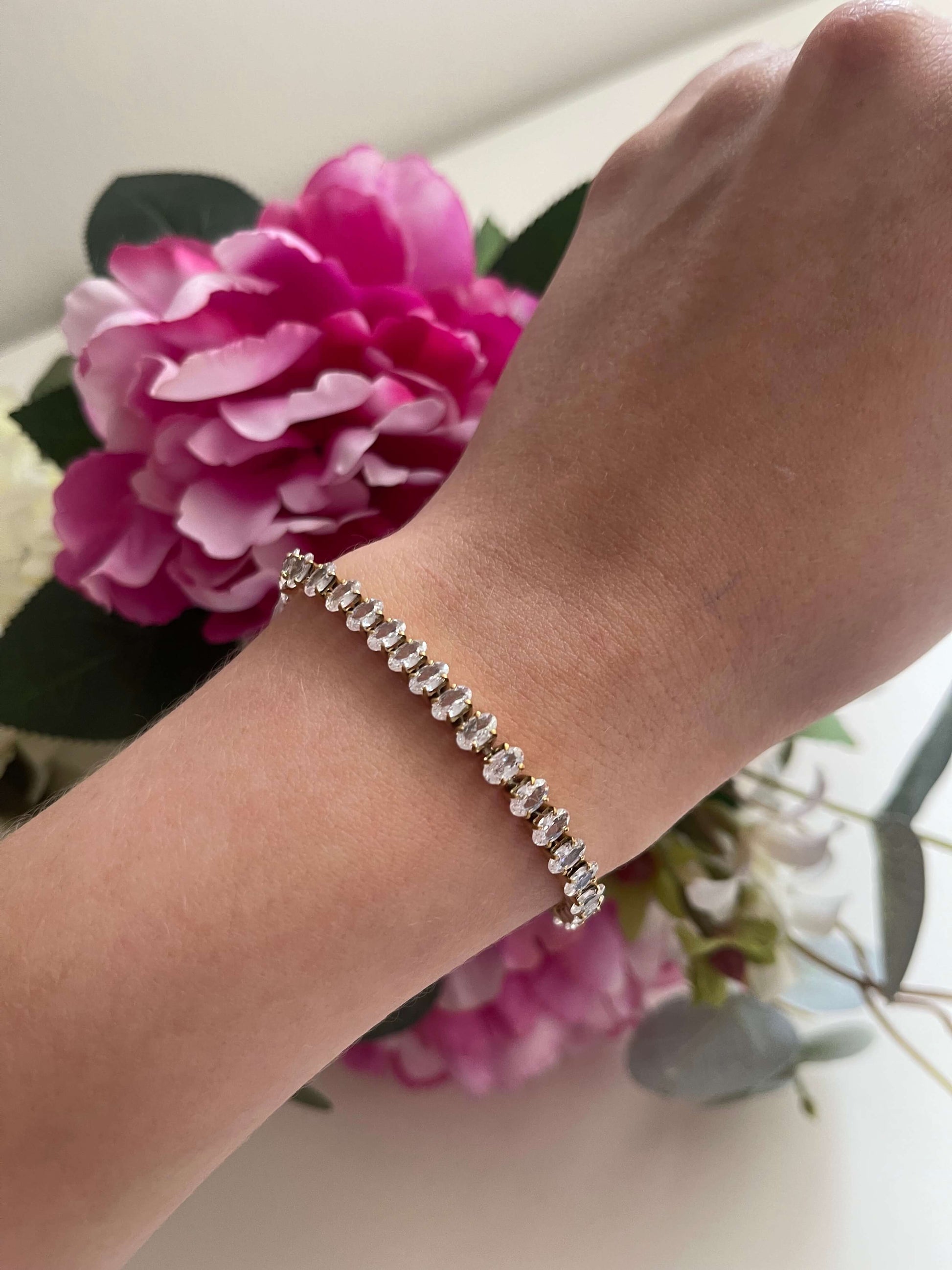 Découvrez l'élégance raffinée du bracelet tennis Chiara , sublimé par ses magnifiques pierres de zircons de coupe ovale. Ce bijou en acier inoxydable de couleur doré ajoute une touche de chic incomparable à votre style.